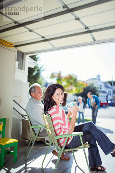 Porträt einer lächelnden Frau beim Kaffeetrinken in der Garage