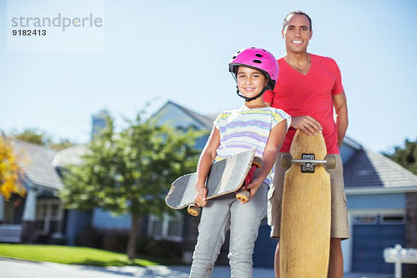 Portrait von Vater und Tochter mit Skateboards