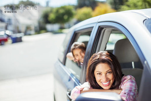 Porträt der lächelnden Mutter und Tochter im Auto