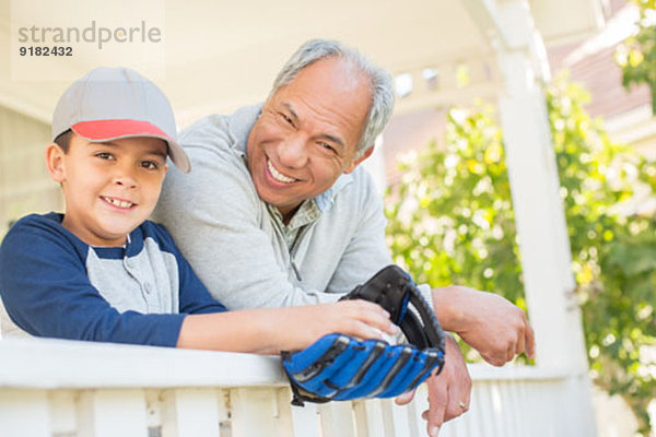 Großvater und Enkel mit Baseballhandschuh auf der Veranda