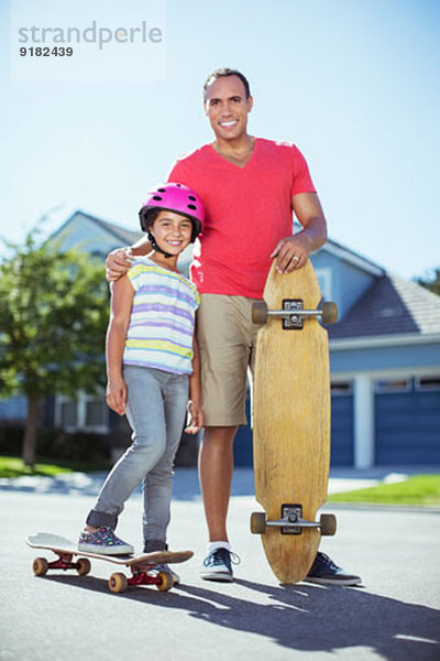 Vater und Tochter mit Skateboards