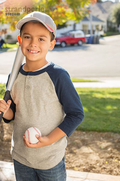 Portrait eines lächelnden Jungen mit Baseball und Schläger