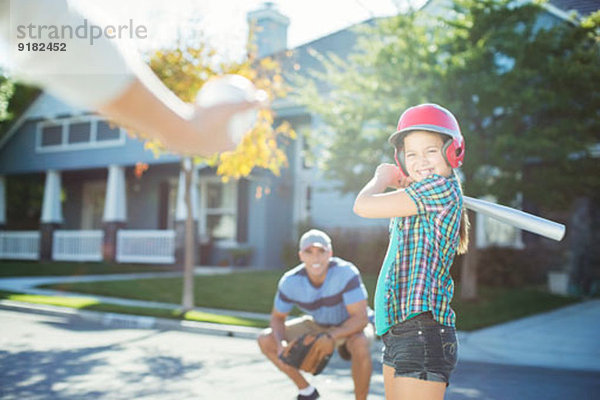 Familie spielt Baseball auf der Straße