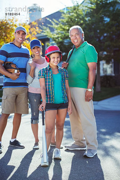 Porträt der glücklichen Mehrgenerationen-Familie beim Baseball auf der Straße
