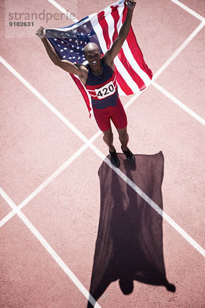 Leichtathlet mit amerikanischer Flagge auf der Bahn