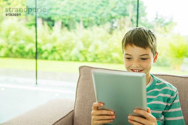 Junge mit digitalem Tablett im Wohnzimmer