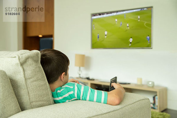 Junge beim Fernsehen im Wohnzimmer