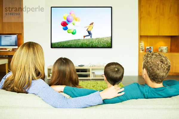 Familie beim Fernsehen im Wohnzimmer