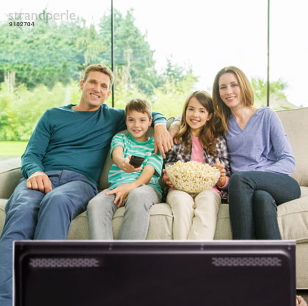 Familie beim Fernsehen im Wohnzimmer