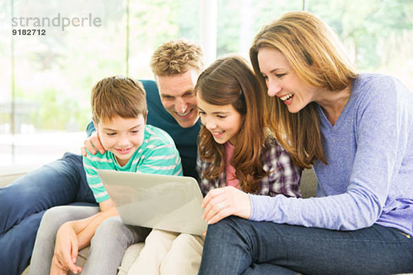 Familie mit Laptop im Wohnzimmer