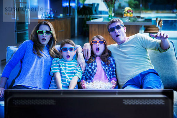 Familie beim 3D-Fernsehen im Wohnzimmer