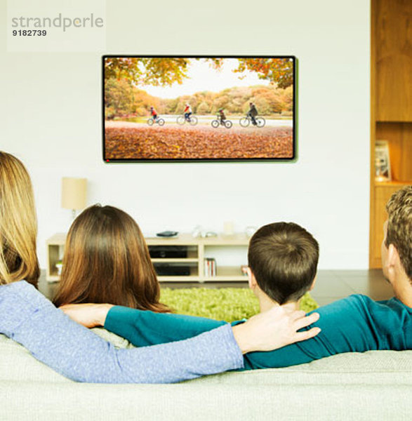 Familie beim Fernsehen im Wohnzimmer