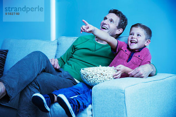 Vater und Sohn beim Fernsehen im Wohnzimmer