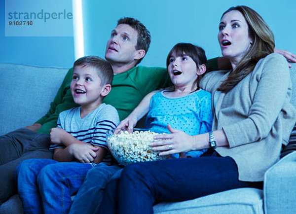 Familie beim Fernsehen im Wohnzimmer