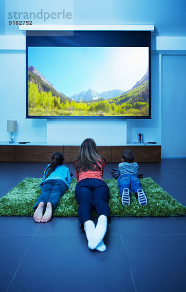 Mutter und Kinder beim Fernsehen im Wohnzimmer