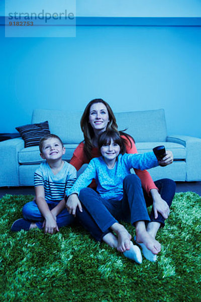 Mutter und Kinder beim Fernsehen im Wohnzimmer