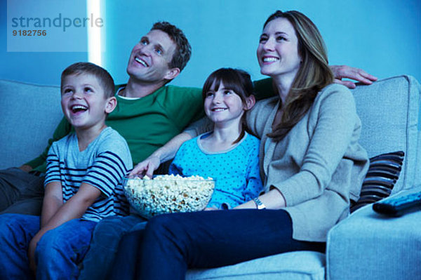 Familie beim Fernsehen im Wohnzimmer