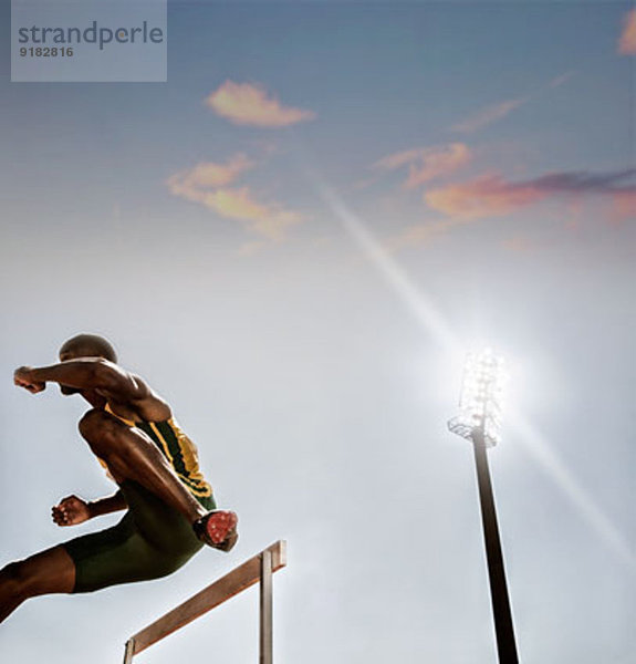 Leichtathletinnen und Leichtathleten überwinden Hürde