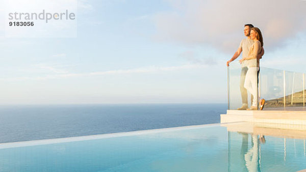 Paar mit Blick auf das Meer vom modernen Balkon aus