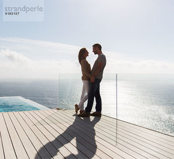 Paar auf modernem Balkon mit Meerblick