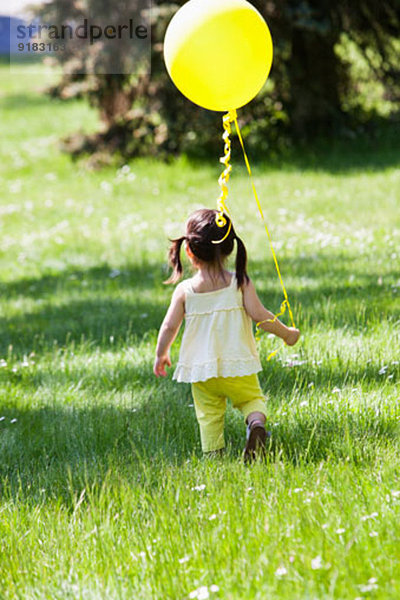 Mädchen mit Ballon im Garten