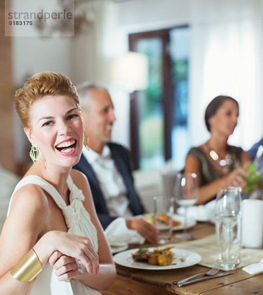 Frau lacht bei der Dinnerparty