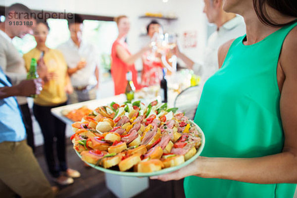 Frau Serviertablett mit Essen auf der Party