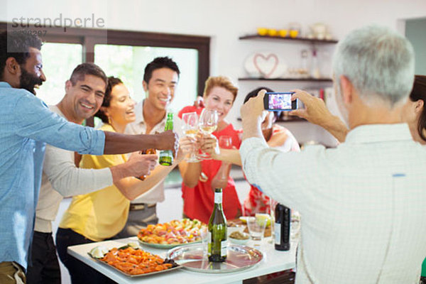 Mann fotografiert Freunde auf der Party