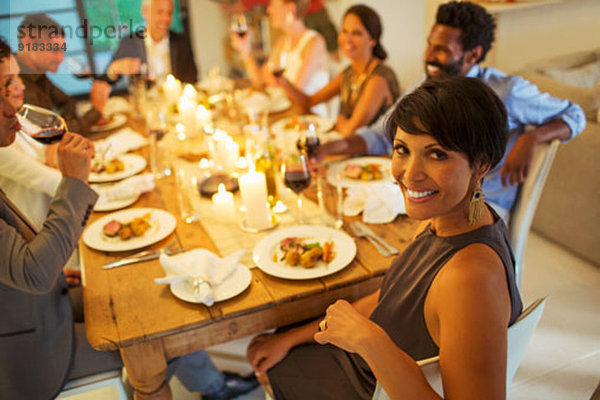 Frau lächelt bei der Dinnerparty