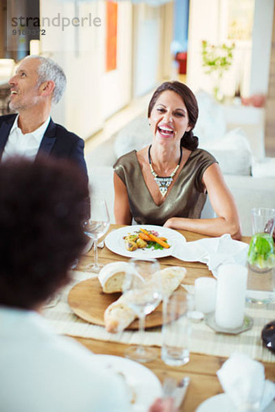 Frau lacht bei der Dinnerparty