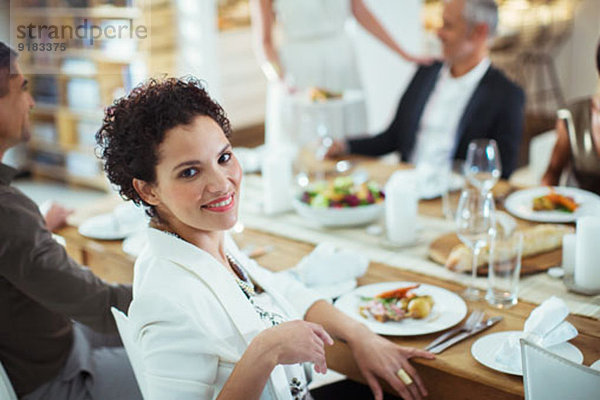 Frau lächelt bei der Dinnerparty