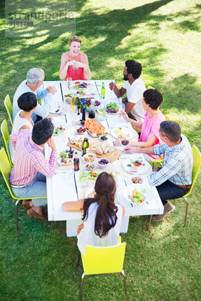 Freunde beim gemeinsamen Essen am Tisch im Freien