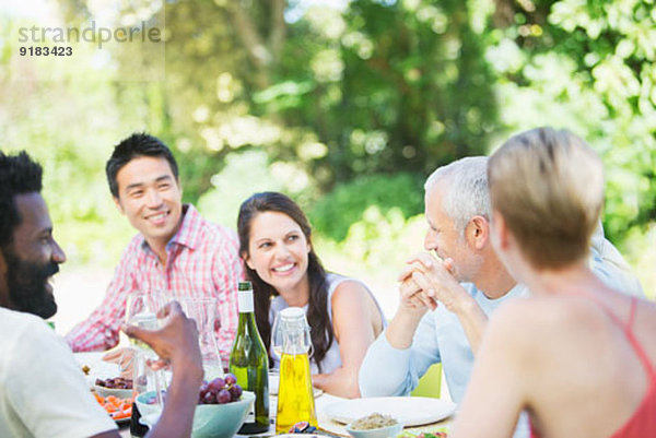 Freunde sprechen am Tisch im Freien