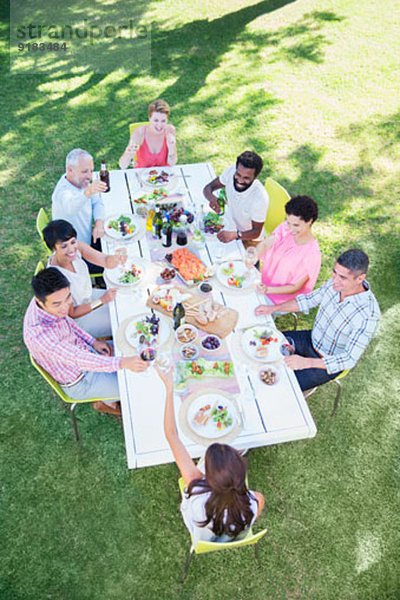 Freunde beim gemeinsamen Essen am Tisch im Freien