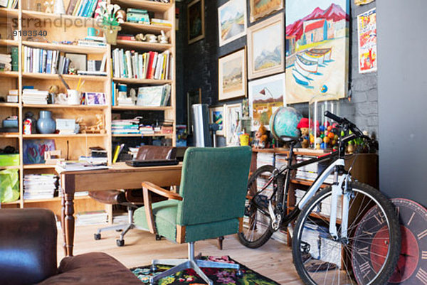 Schreibtisch  Bücherregale und Fahrrad im Arbeitszimmer