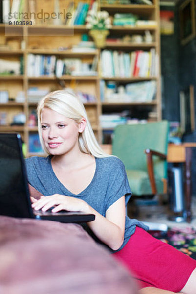 Frau mit Laptop im Wohnzimmer