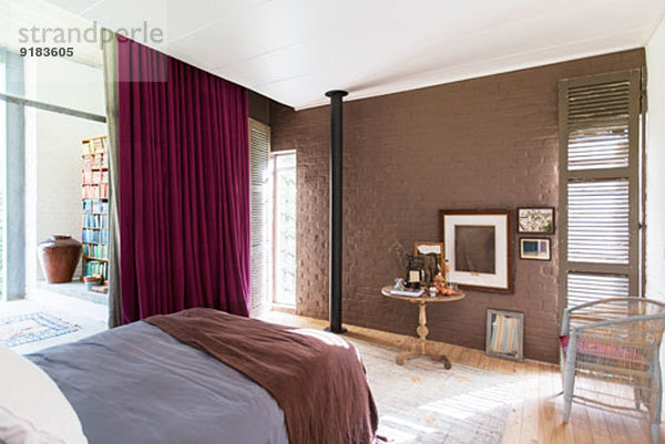Bett  Beistelltisch und Bilder im rustikalen Schlafzimmer