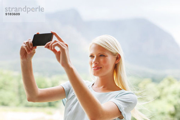 Frau fotografiert in ländlicher Landschaft