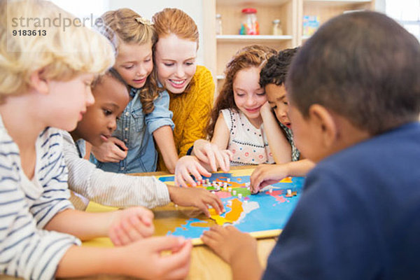 Lehrer spielt mit Schülern im Klassenzimmer