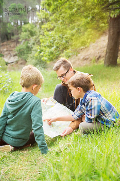 Schüler und Lehrer lesen Karte im Feld