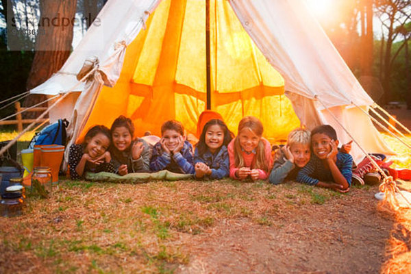 Kinder lächeln im Tipi auf dem Campingplatz