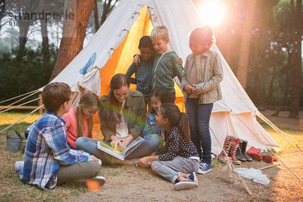 Lehrer und Schüler beim Lesen auf dem Campingplatz