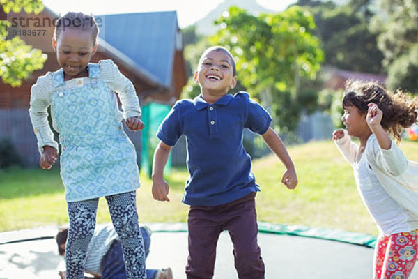 Kinder springen auf Trampolin im Freien