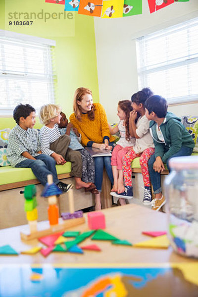 Lehrer und Schüler beim Lesen im Klassenzimmer