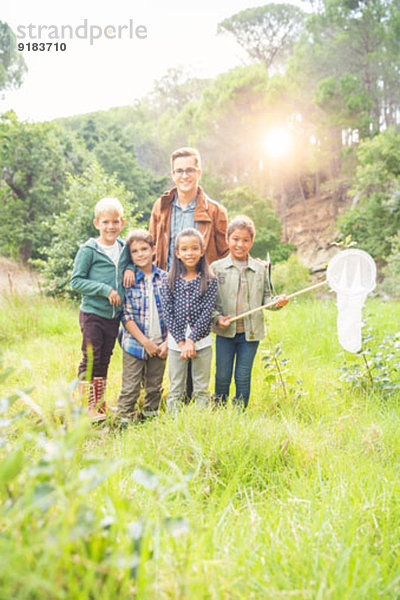 Schüler und Lehrer lächeln im Feld