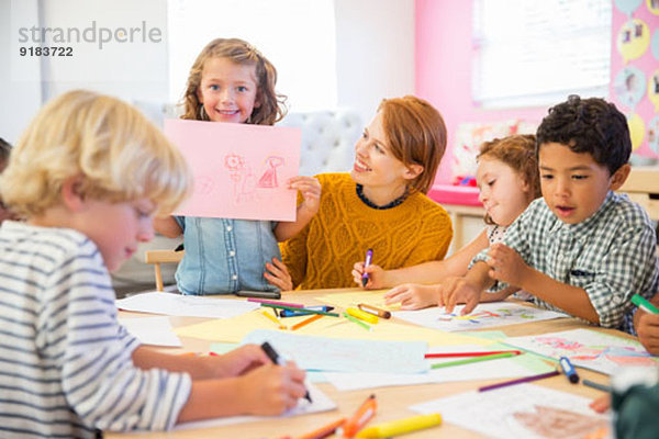 Schüler zeigt Zeichnung im Klassenzimmer