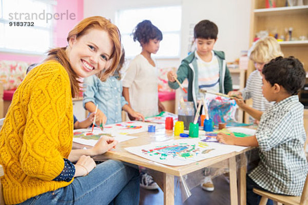 Lehrer und Schüler malen im Klassenzimmer