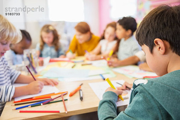 Lehrer und Schüler zeichnen im Klassenzimmer