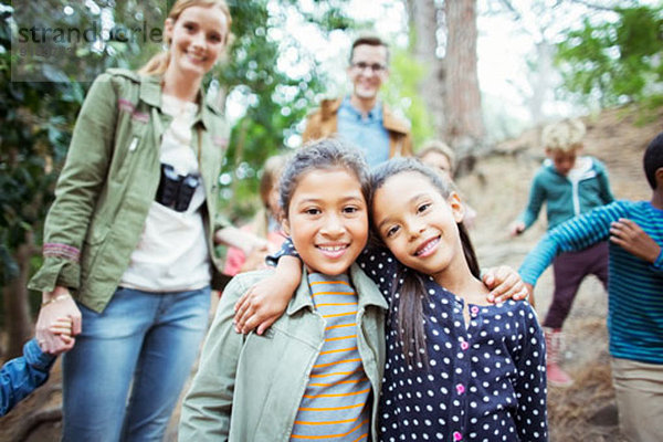 Schüler und Lehrer lächeln im Wald