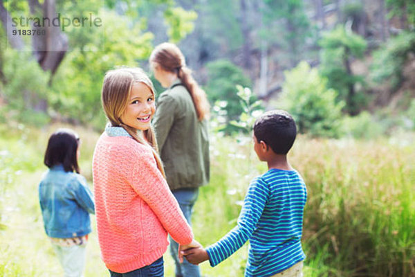 Kinder halten sich auf dem Feld an den Händen